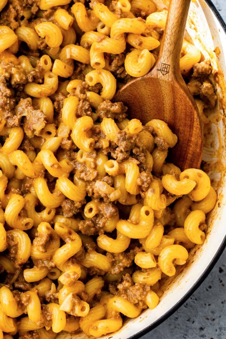 Ground beef, macaroni and cheese in a skillet.