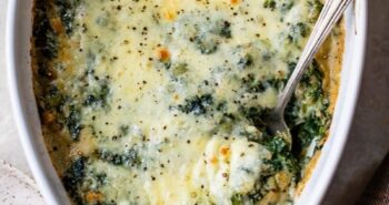 Spinach Gratin in a casserole dish with a serving spoon.