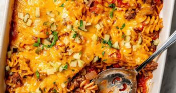Overhead view of cheeseburger casserole in baking dish with serving spoon