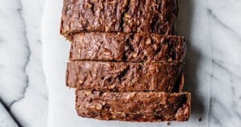 Overhead view of sliced Chocolate Zucchini Bread loaf on white marble
